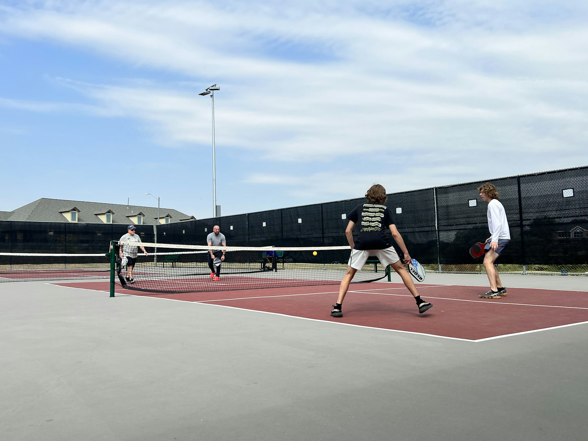 Group of pickleball players on an outdoor court — AED access is essential at busy recreational facilities